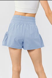 Light blue active shorts with gathered waistline and ruffled side pockets.