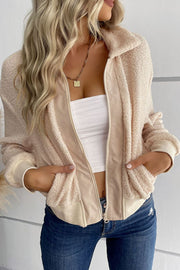 Cream teddy fleece bomber jacket with collared neck and zip front, styled with a white tube top and jeans.
