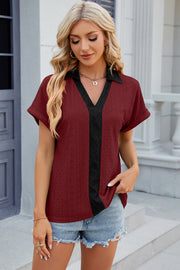 Burgundy perforated polo top with black V-neck panel and short sleeves