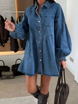 Blue denim mini dress with pockets, button-down front, and voluminous sleeves.