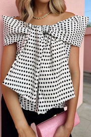 Chic off-shoulder polka dot blouse with a large bow detail.