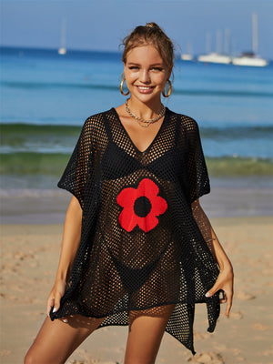 Black crochet beach cover-up with red daisy appliqué and v-neck.