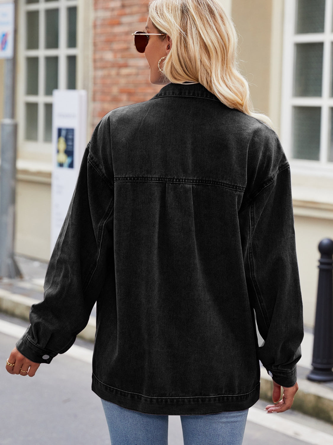Black denim oversized shacket with button cuffs and collar detail.