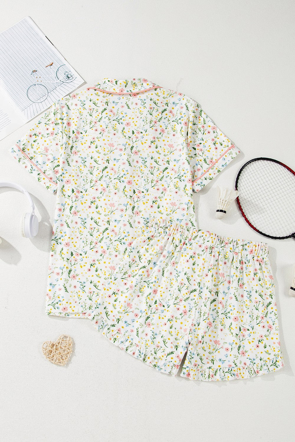 Ivory floral print pajama set with button-up top and shorts, featuring pink trim.