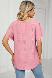 Pink eyelet blouse with flutter sleeves and a tie-neck detail.