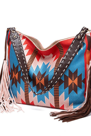 Southwestern fringe hobo bag with geometric pattern in multicolor canvas and brown leather trim.