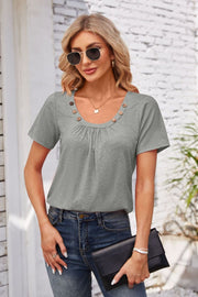 Gray short sleeve top with gathered yoke and button trim neckline.