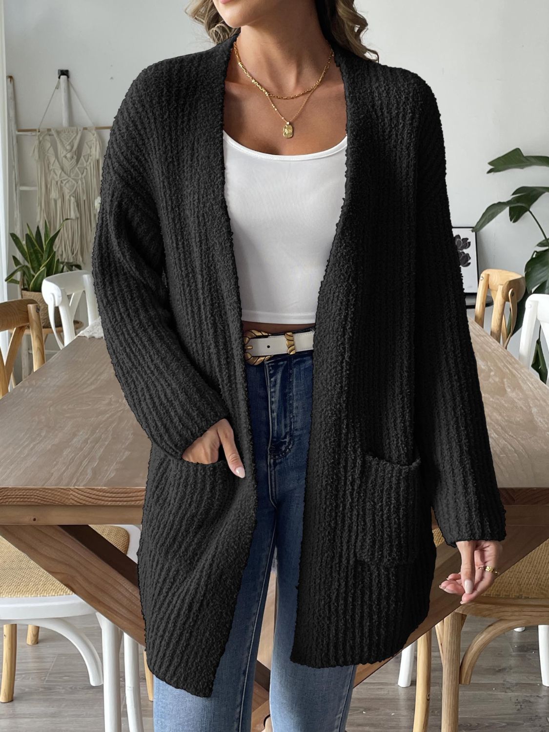 Black textured bouclé open-front cardigan with pockets and long sleeves.
