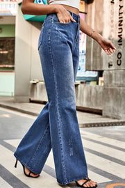Flared denim jeans in medium blue with subtle distressing and a button closure.
