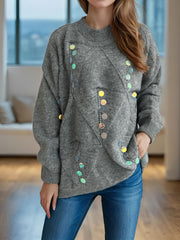 Gray knit sweater with geometric sequin embellishments and a crew neck.