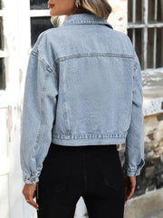 Light wash boxy cropped denim trucker jacket with buttoned cuffs and collar.