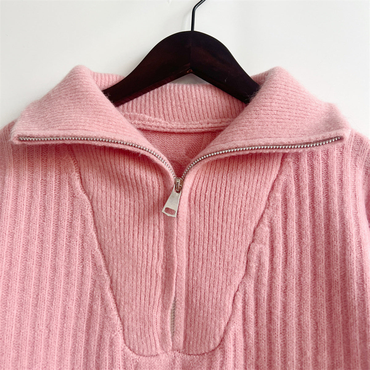 Dusty pink cable knit zip-neck sweater with a ribbed texture and silver zipper detail.
