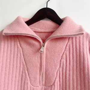 Dusty pink cable knit zip-neck sweater with a ribbed texture and silver zipper detail.