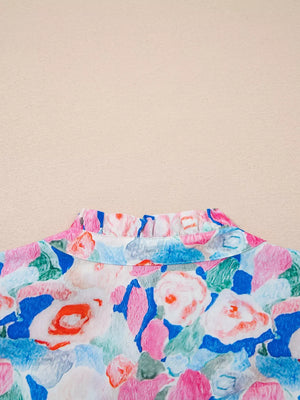Vibrant floral cotton blouse with a ruffled tie neck.
