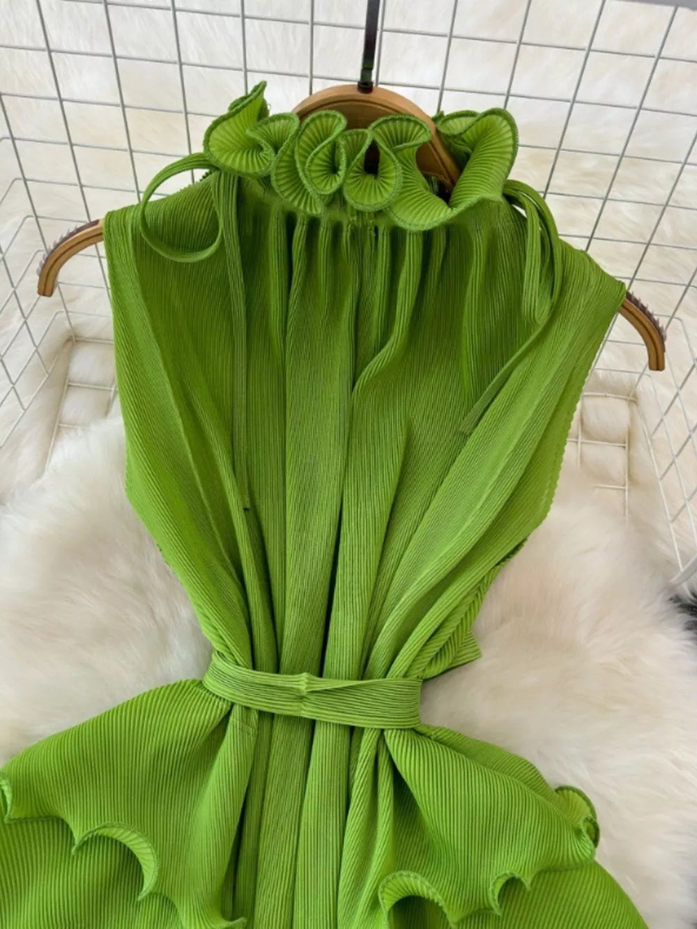 Lime green pleated midi dress with ruffled neckline and belted waist.