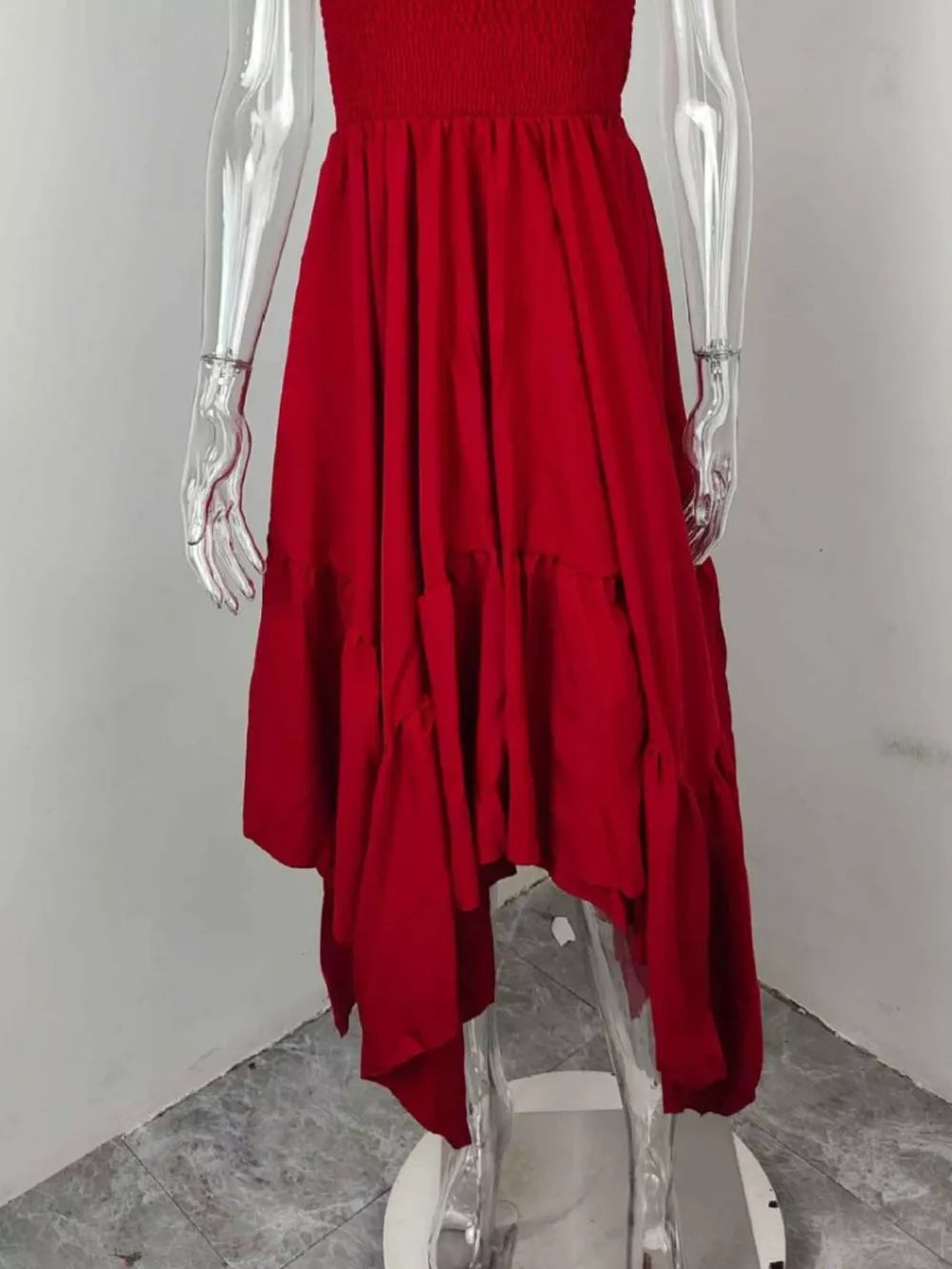 Deep red smocked maxi dress with ruffle hem and flowing skirt.