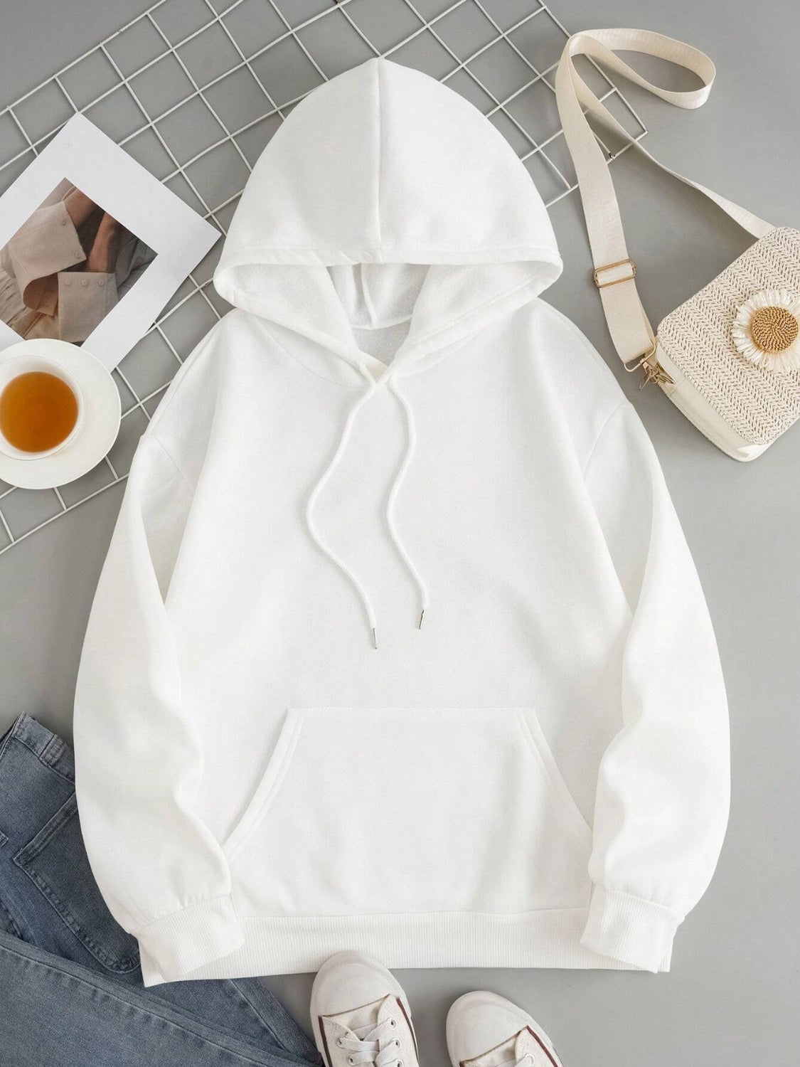 Oversized white hoodie with drawstring, pouch pocket, and ribbed cuffs.