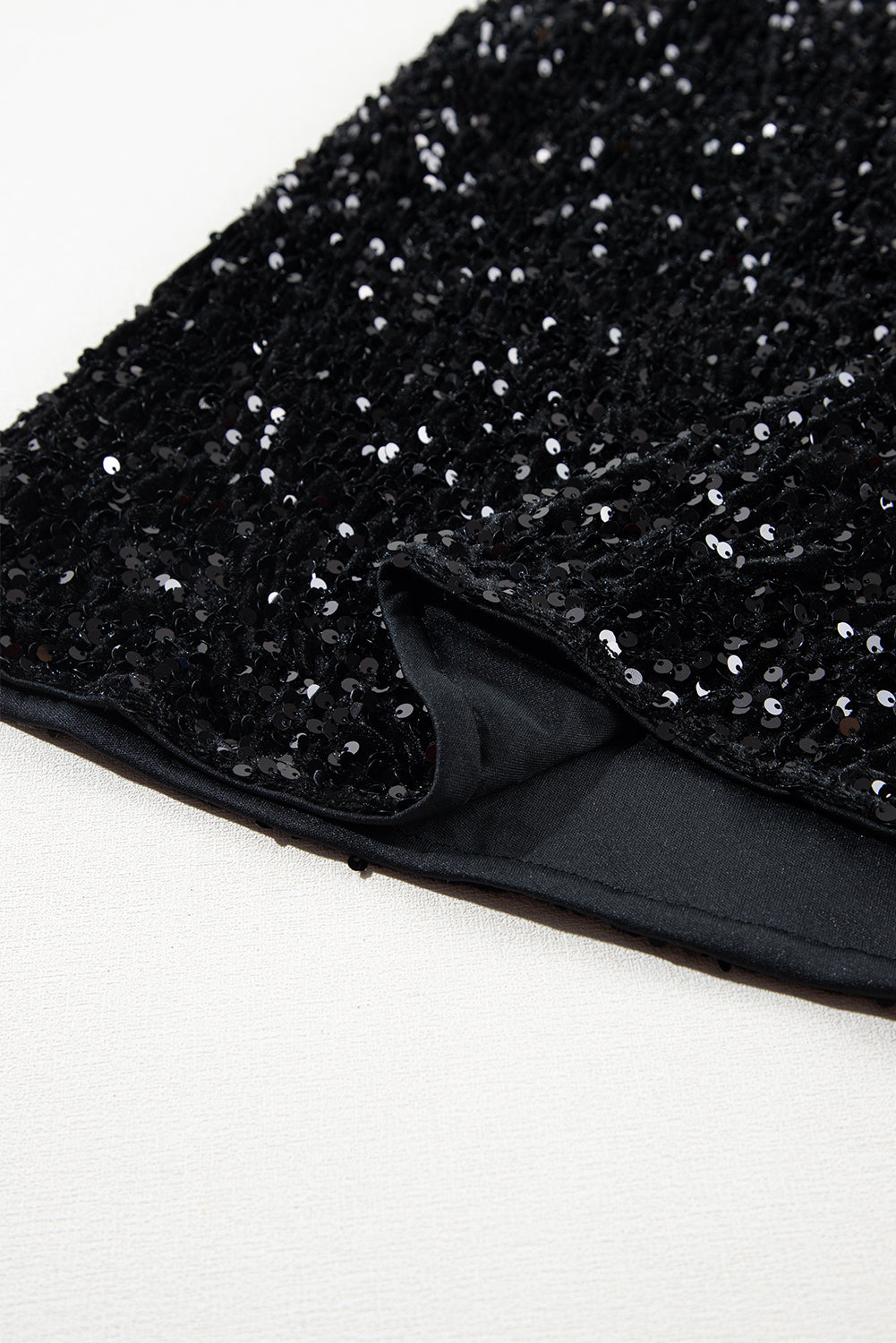 Black sequin mini skirt with body-hugging fit and smooth lining detail.