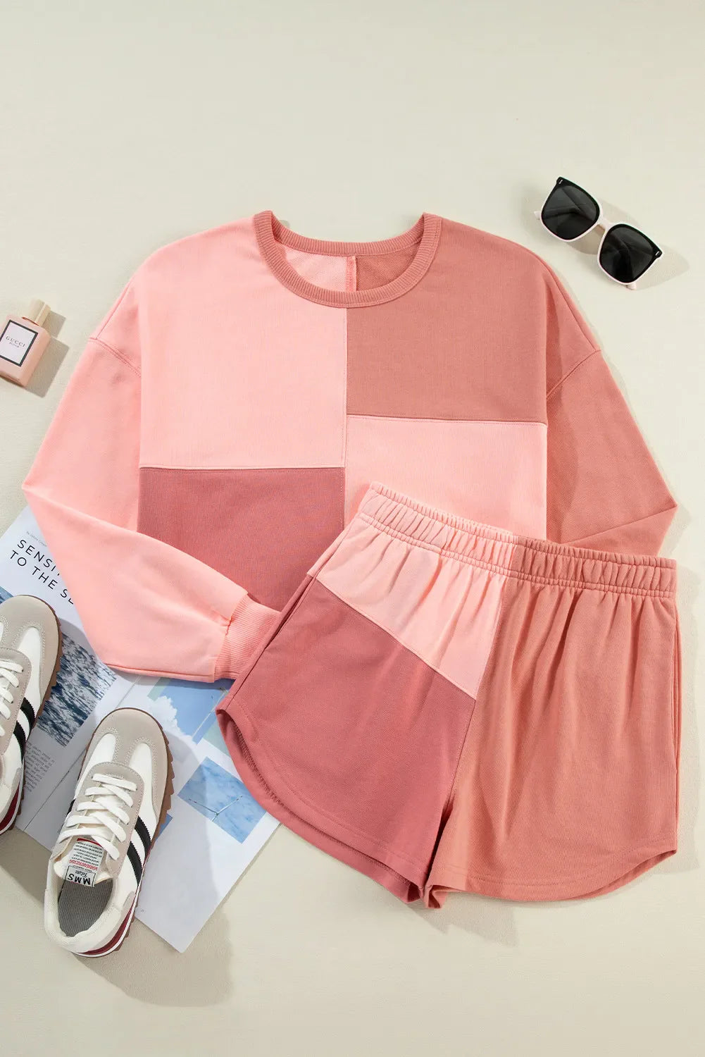Colorblock lounge set with crew neck sweatshirt and shorts in dusty pink and light blue tones.