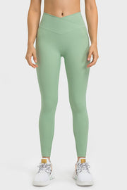 Mint green performance leggings with sculpted waistband and pockets, full length.
