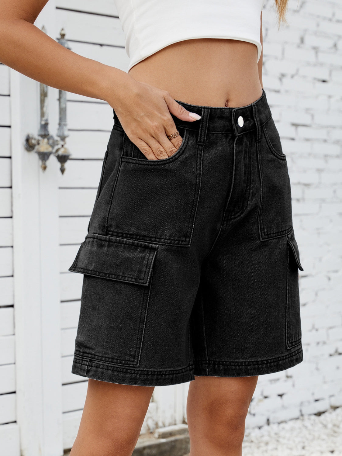 Black denim Bermuda shorts with cargo pockets and a casual fit.