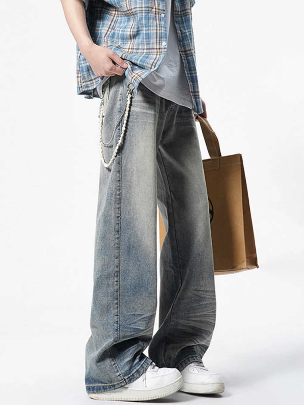 Timeless wide leg vintage jeans in light wash denim with distressed details and a pearl chain accessory.