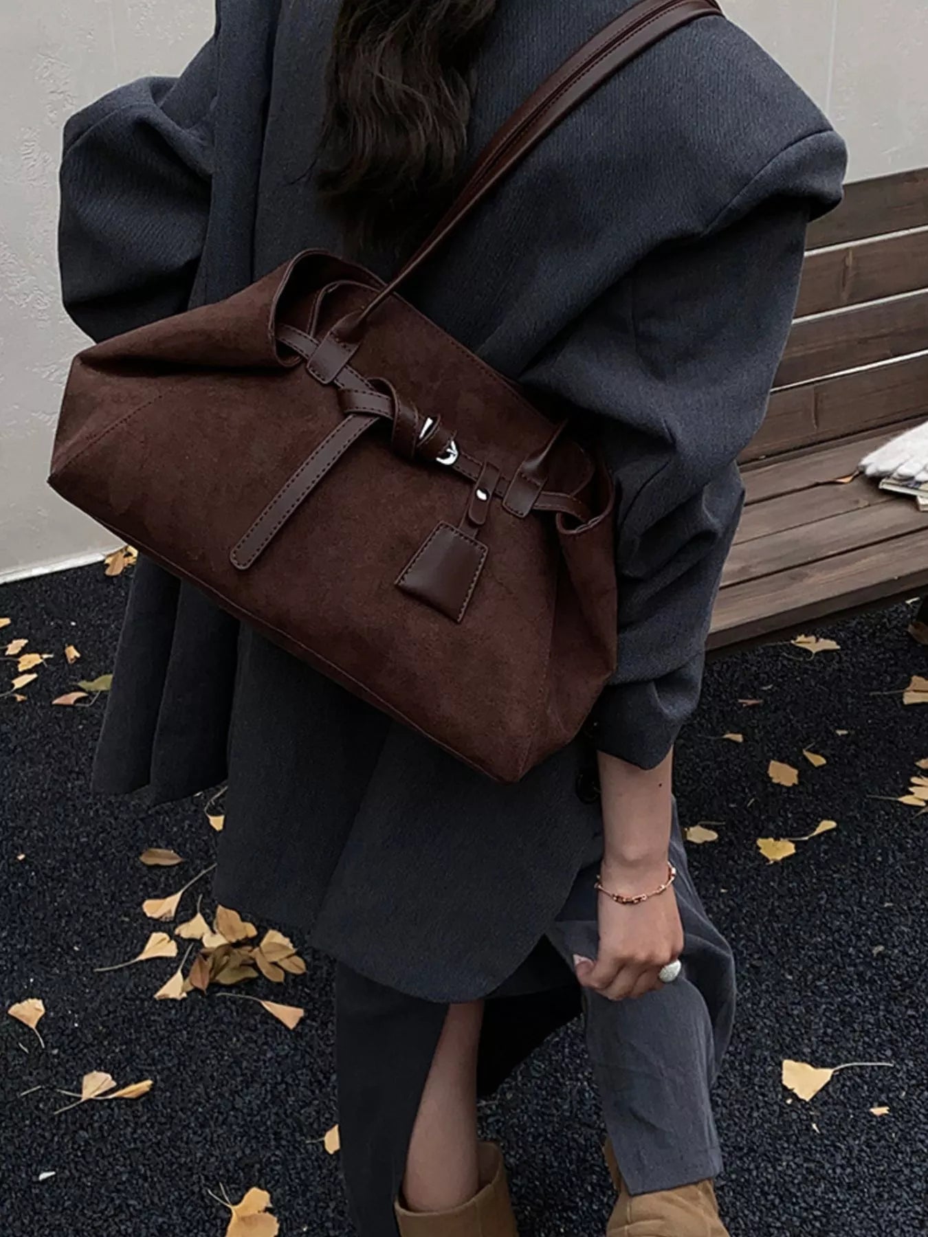 Women's brown suede shoulder bag with tie closure and leather details.