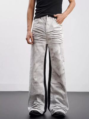 Men's wide-leg jeans in grey tie-dye cotton with black contrast stripes and ruched detail.