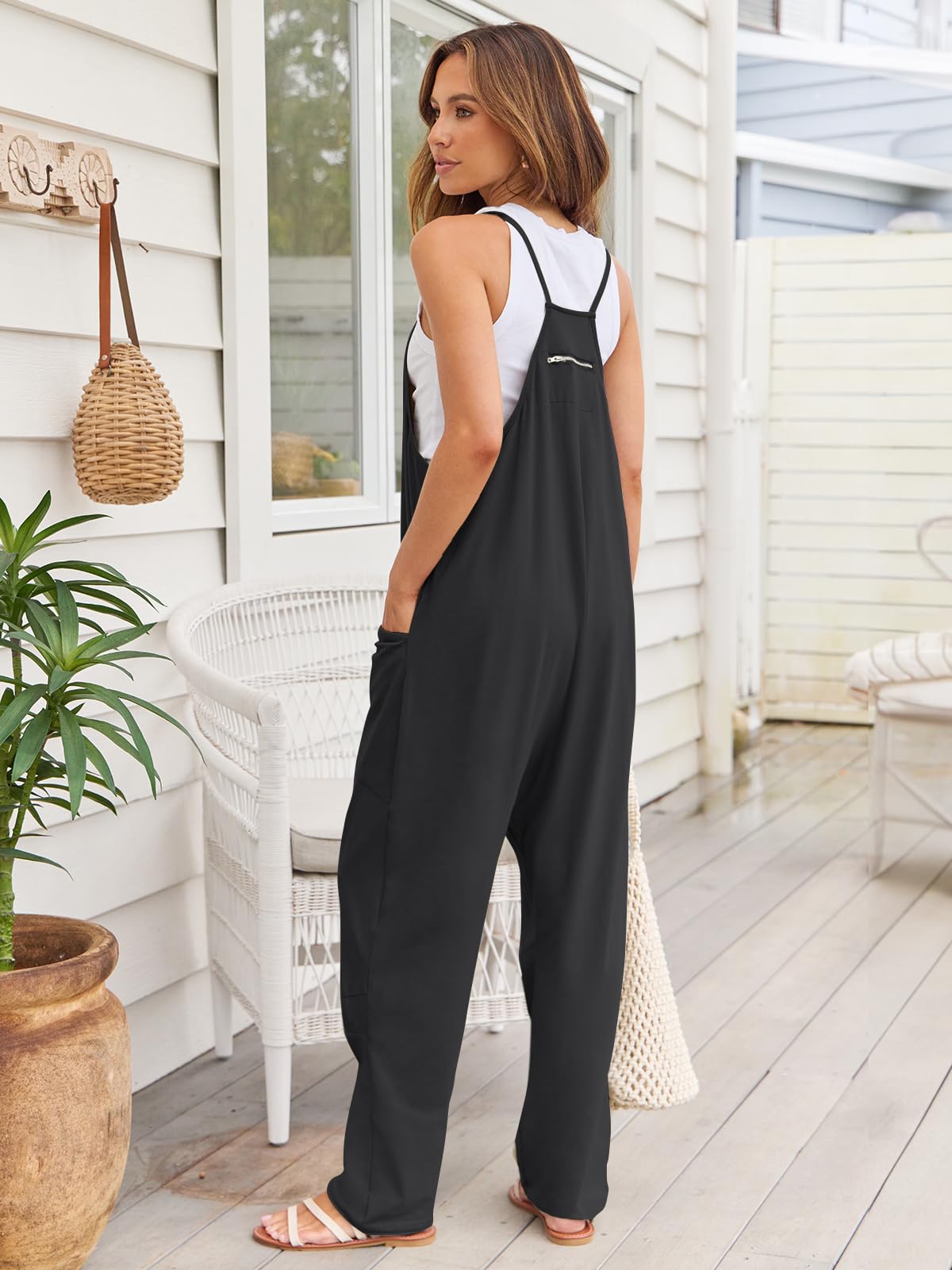 Black relaxed pocketed overalls jumpsuit with zipper detail and wide legs.