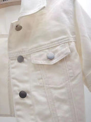 White denim trucker jacket with cropped sleeves and silver buttons.