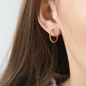 Gold vermeil huggie earrings, thin hoop style, on ear