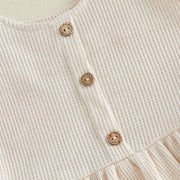 Apricot waffle knit tank top with wooden buttons and ruffled hem detail.