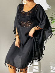 Black crochet yoke tassel kaftan dress with wide sleeves and fringed hem.