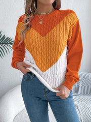 Chevron cable knit sweater with contrast orange, yellow, and white panels.