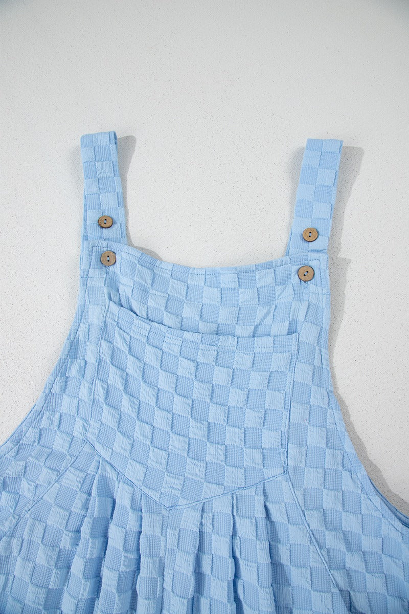 Light blue textured checkered jumpsuit with button straps and a chest pocket.