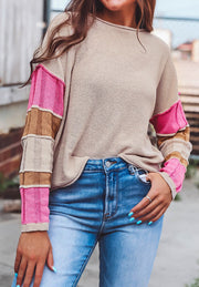 Beige knit sweater with color block sleeves in pink and brown, crew neck, casual style.