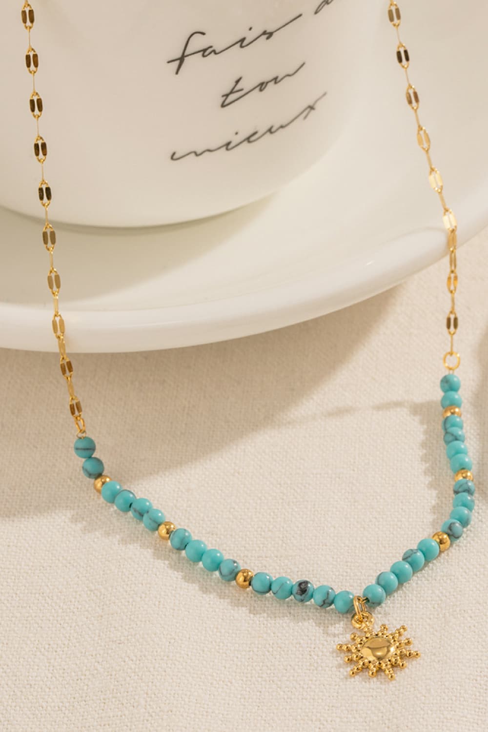 Gold celestial sunburst beaded necklace with turquoise and gold beads
