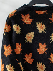 Black knit jumper with autumnal orange leaf motif, crew neck, long sleeves.