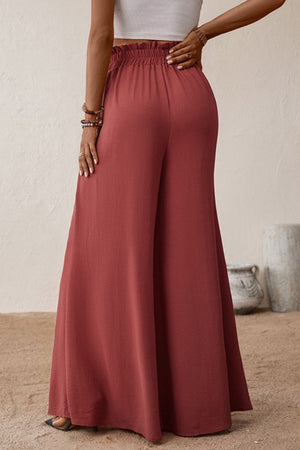 Crimson palazzo trousers with paperbag waist and wide leg, styled with a white crop top.