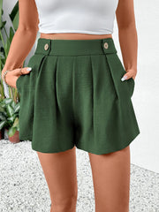 Dark green high-waisted pleated shorts with button detail and pockets