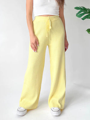 Pastel yellow ribbed knit palazzo trousers with drawstring waist, styled with a white crop top.