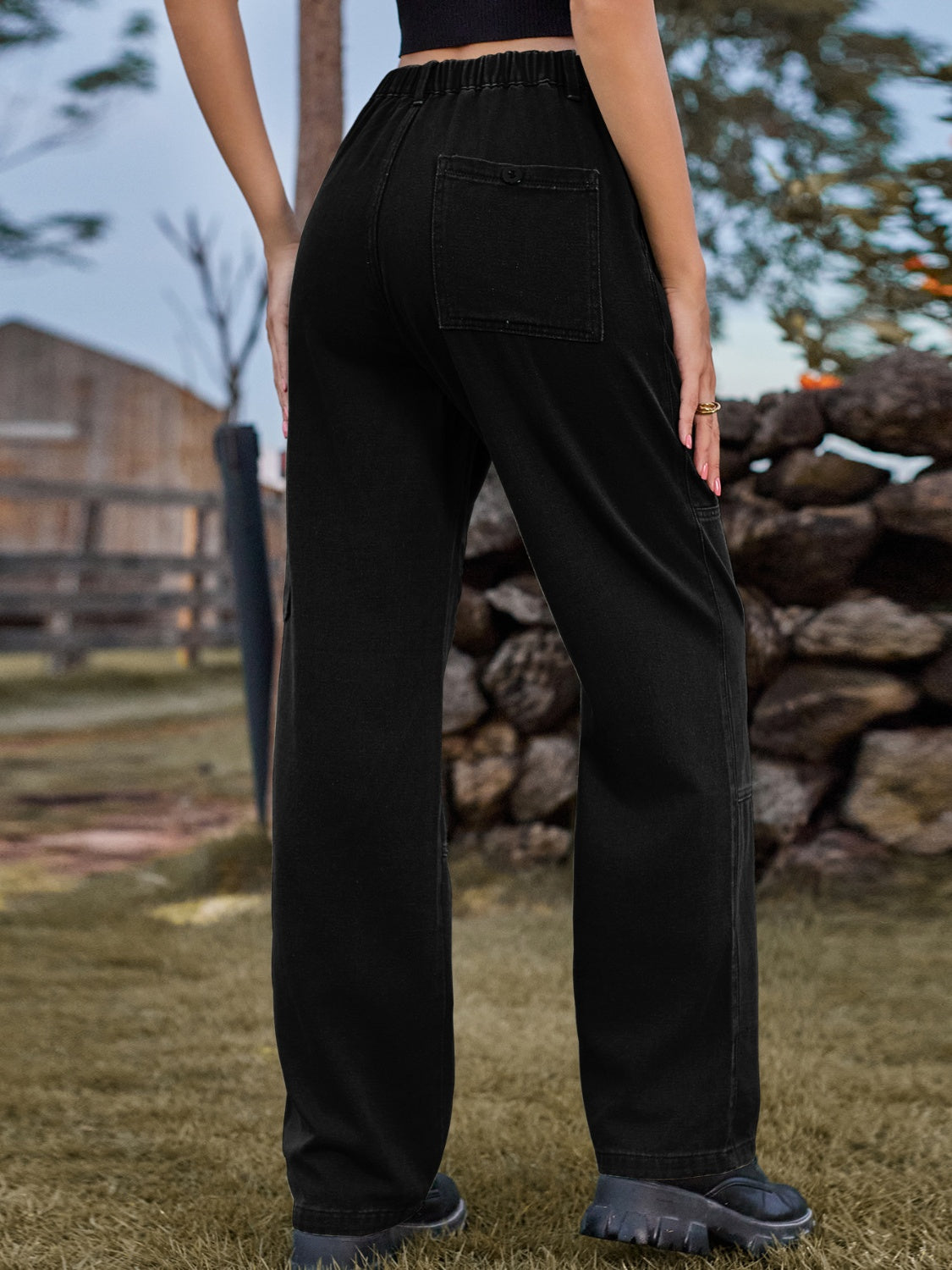 Black denim cargo pants with elastic waist and back pocket detail.