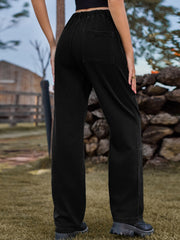 Black denim cargo pants with elastic waist and back pocket detail.