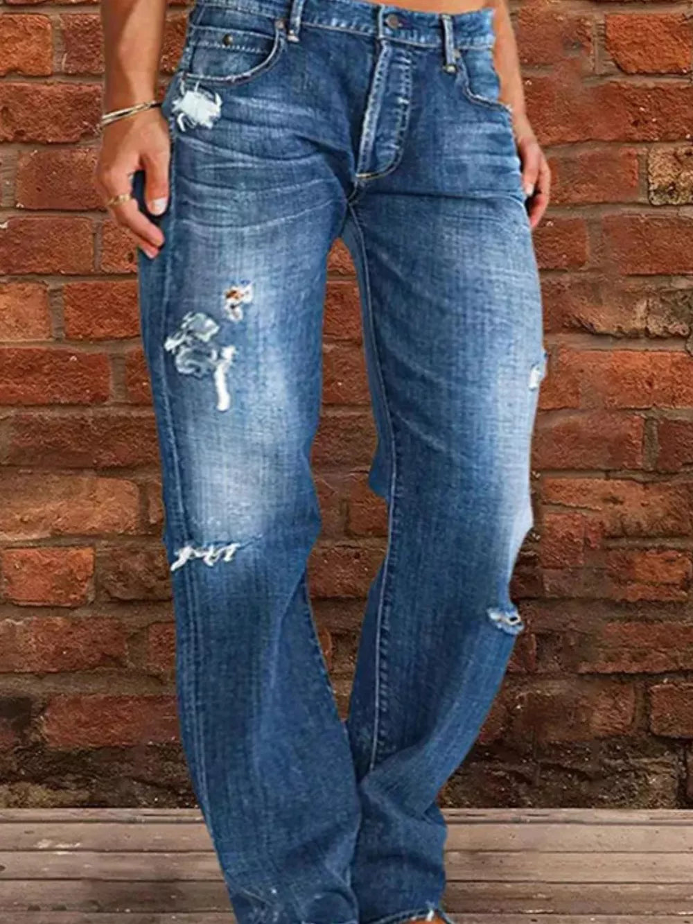 Blue denim maternity jeans with relaxed fit, distressed details, and raw hem