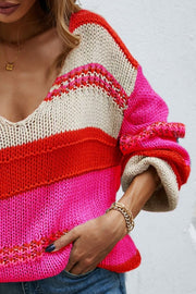 Deep Plunge Colorblock Knit Pullover in pink, red, and cream with a V-neck and long sleeves.