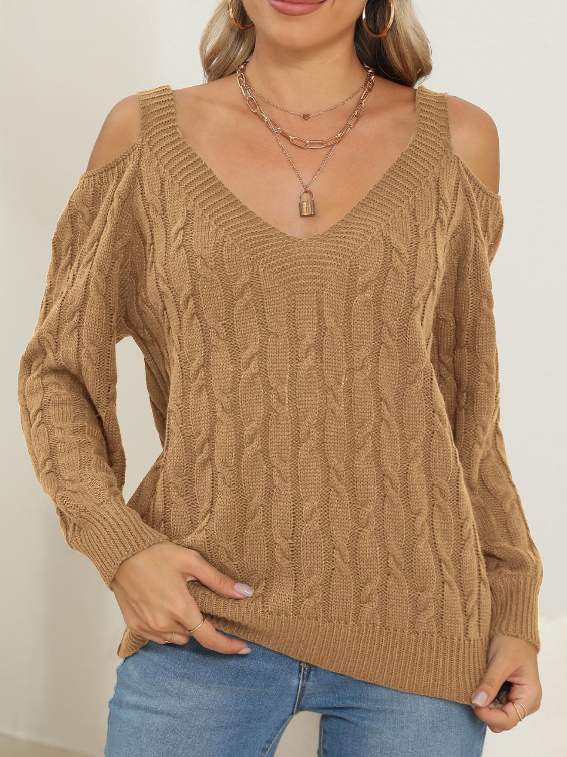 Camel cable knit cold shoulder sweater with V-neck and balloon sleeves.