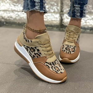 Leopard print lace-up sneakers with brown and tan color-blocking and a gold chain ankle strap.