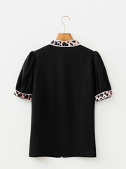Black puff sleeve blouse with leopard print trim on collar and cuffs.
