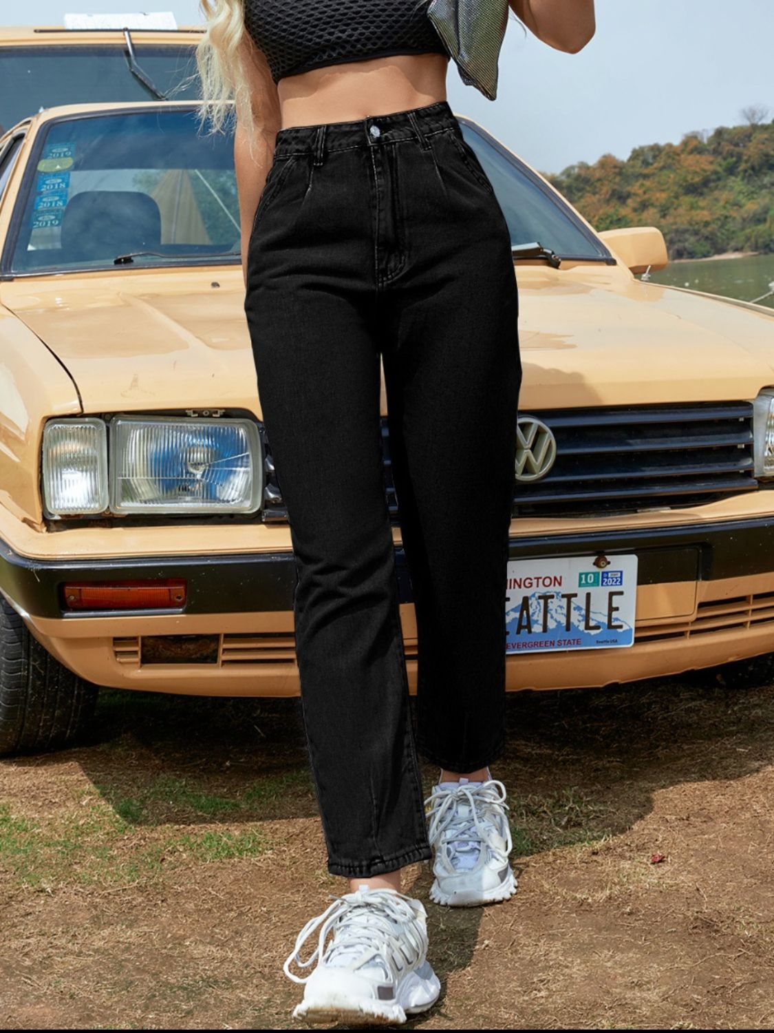 Black high-waisted tapered denim trousers with a button closure and casual styling.
