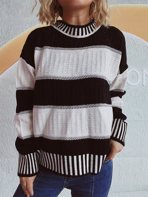 Black and white striped mock neck knit sweater with textured panels.